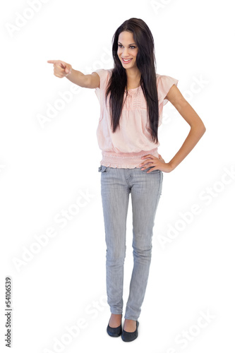 Smiling young woman pointing at something