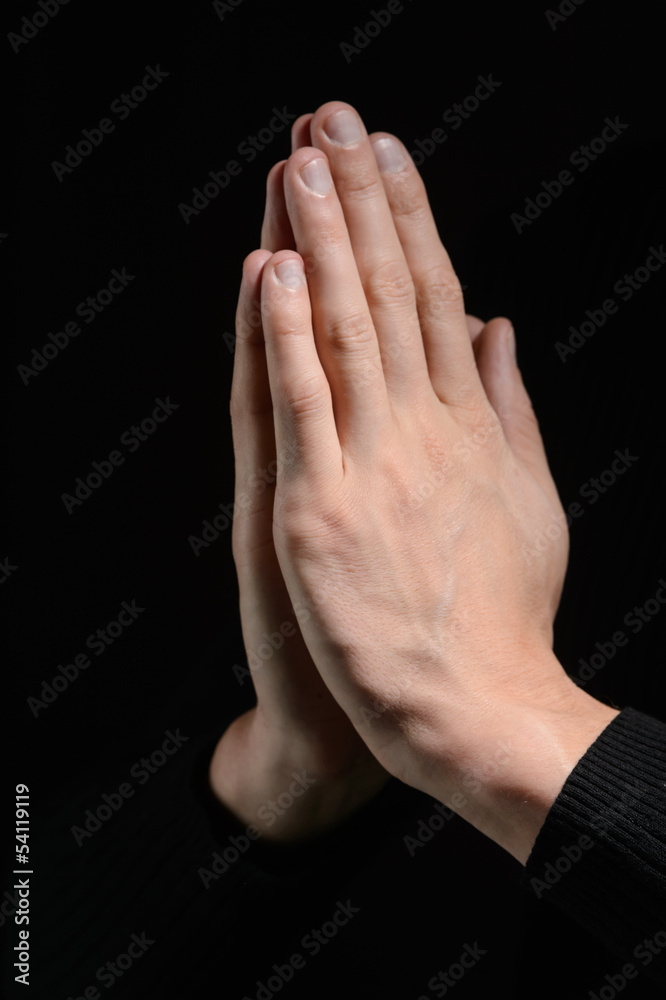 Hands clasped. Close-up of hands clasped isolated on black Hands clasped. Close-up of hands clasped isolated on black
