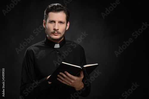 Priest with Holy Bible. Portrait of priest reading the Holy Bibl