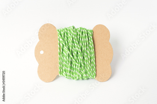 Green yarn thread roll on paper