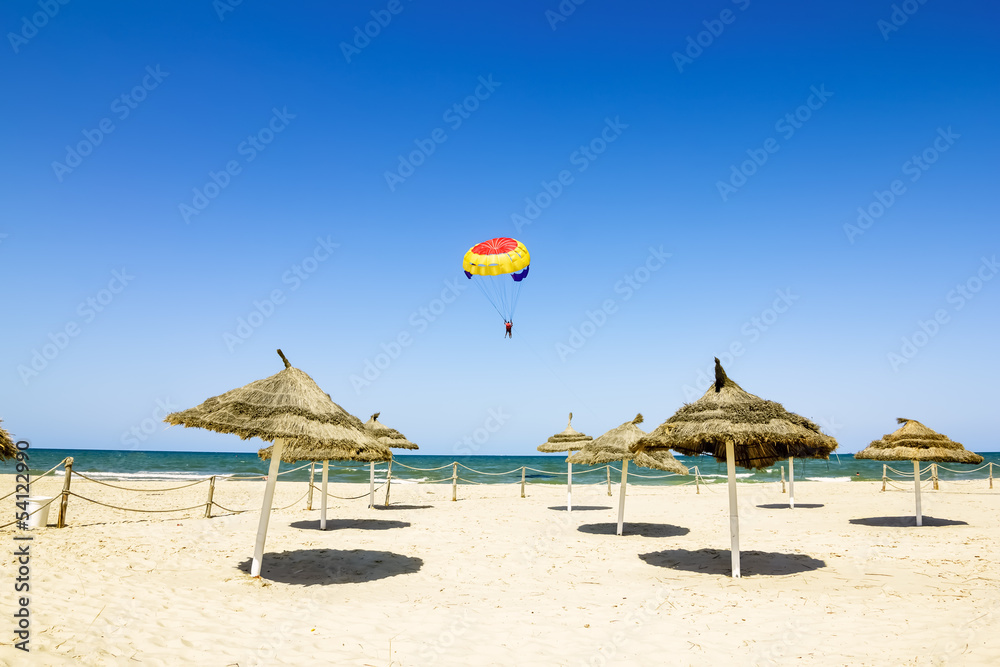 Parachute flies over the Mediterranean Sea and the beaches of Tu