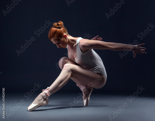 Obraz na plátně Graceful slender ballerina dancing in studio