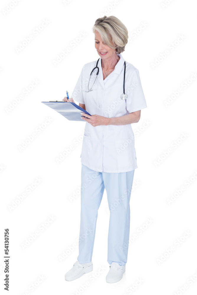 Mature Female Doctor Writing On Clipboard Mature Female Doctor Writing On Clipboard