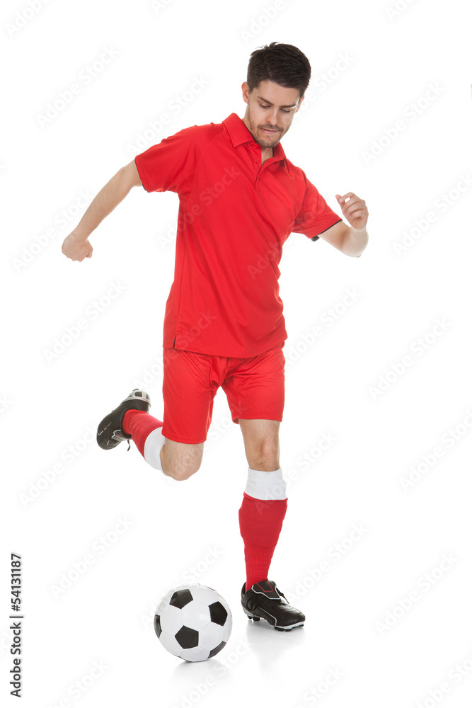 Portrait Of Soccer Player Kicking Ball