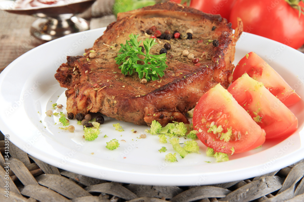 Piece of fried meat on plate on wooden table close-up