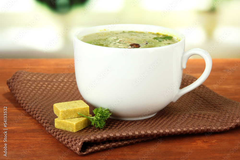 Cup of soup with bouillon cubes on wooden table Cup of soup with bouillon cubes on wooden table