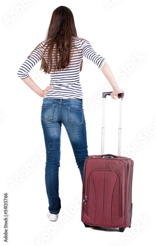 Back view of stylishly dressed brunette woman  with  suitcase lo