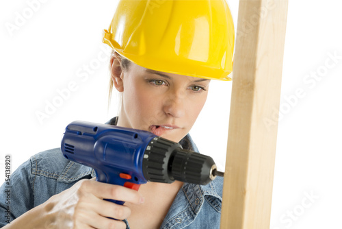 Construction Worker Biting Lip While Drilling Wooden Plank