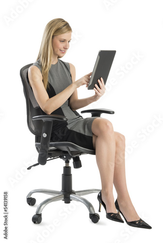 Businesswoman Using Digital Tablet While Sitting On Office Chair