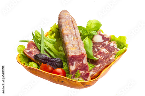 Ripe salami with salad, basil, onion and tomato