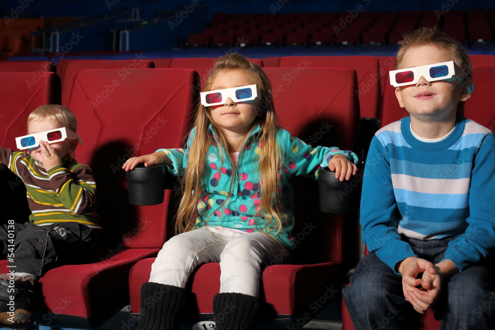 small children in 3D glasses watching movie in cinema