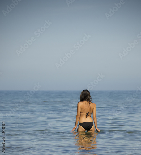 woman in bikini stands in water