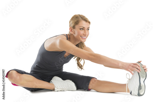 Woman Smiling While Stretching To Touch Her Toes