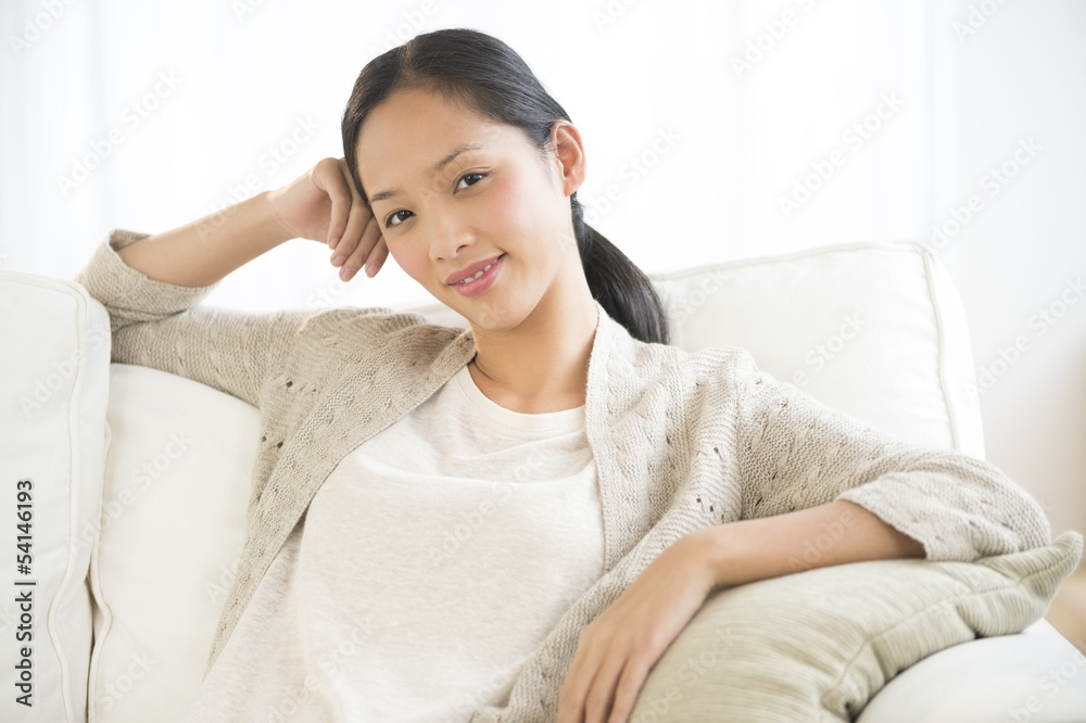 Attractive Woman Smiling While Relaxing On Sofa Attractive Woman Smiling While Relaxing On Sofa