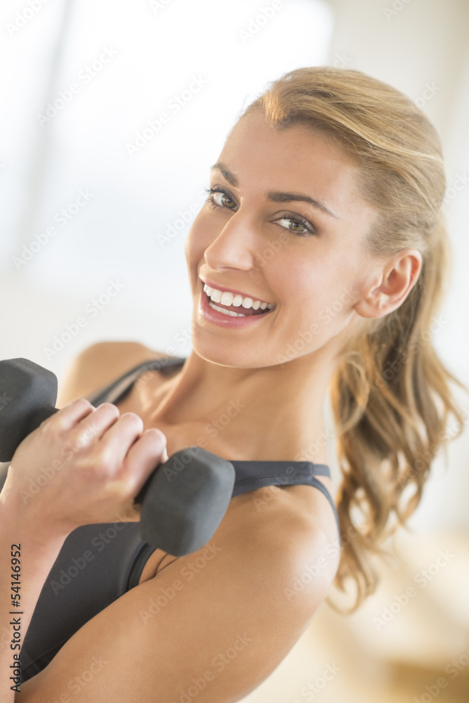 Fit Woman Lifting Weights At Gym