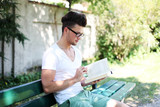 hübscher Junge ließt ein Buch im Park