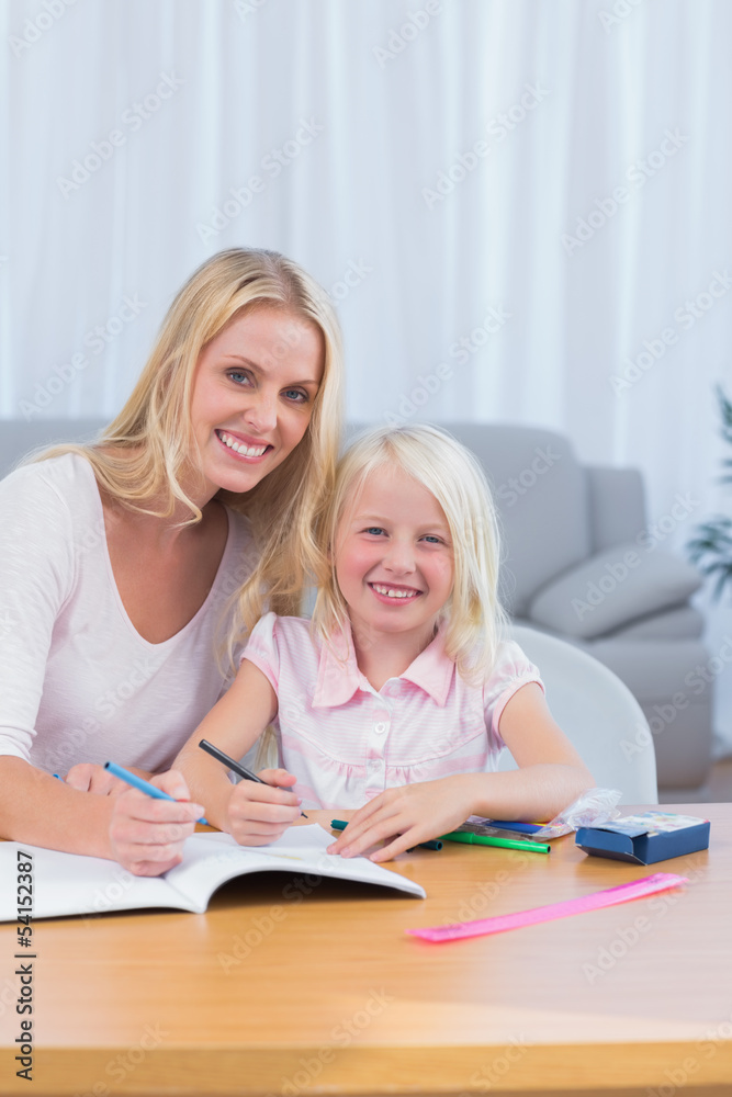 Smiling mother and daughter drawing together Smiling mother and daughter drawing together