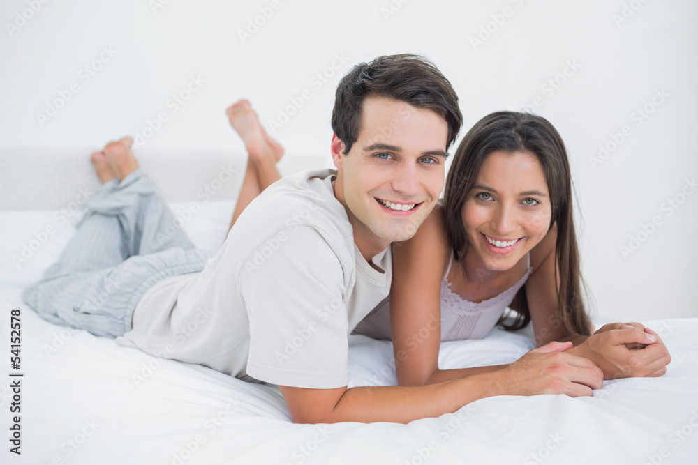 Young couple lying together in bed Young couple lying together in bed