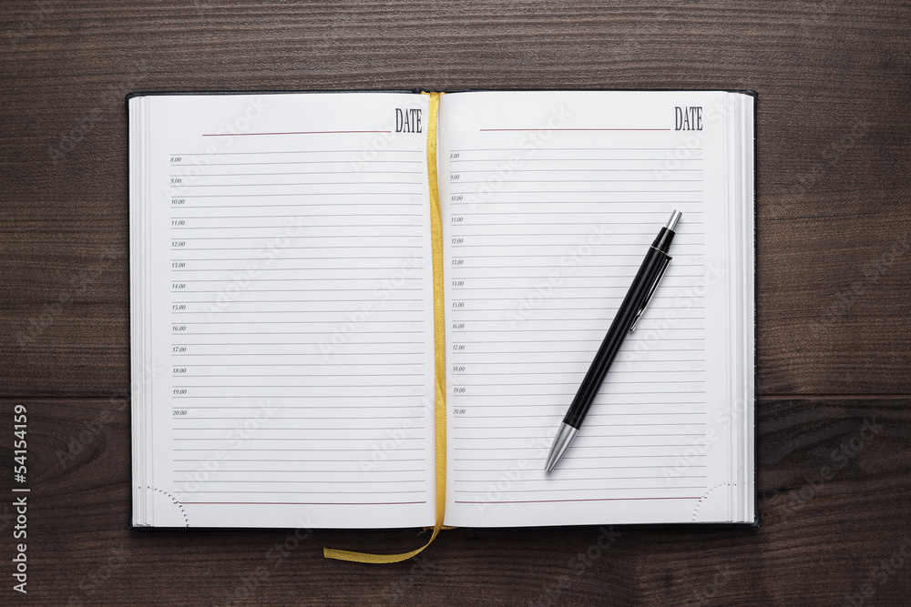 opened notebook and pen on wooden table opened notebook and pen on wooden table