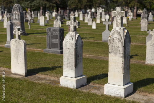 Obraz na plátně An old section of a small town graveyard during daylight.