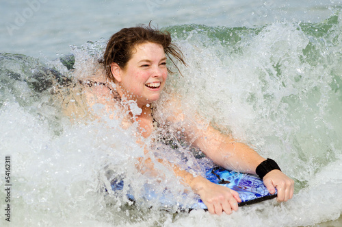 Woman surfing on bodyboard at beach