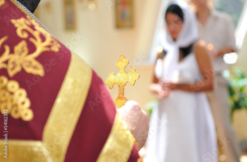 Golden cross in hands of priest.