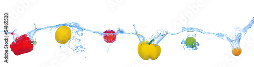 Tropical fruits and vegetables falling into water with splash