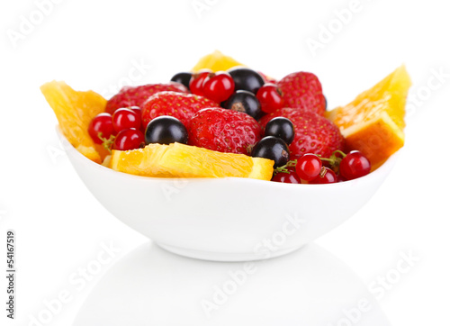 Useful fruit salad of fresh fruits and berries in bowl isolated