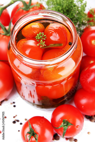 Open glass jar of tasty canned tomatoes, isolated on white