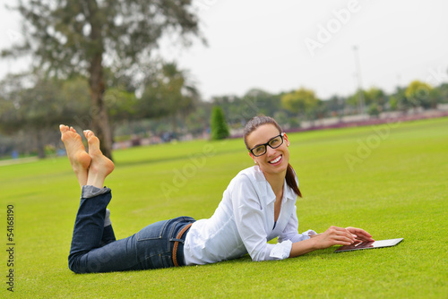 Beautiful young woman with tablet in park