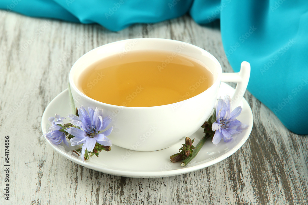 Cup of tea with chicory, on wooden background Cup of tea with chicory, on wooden background
