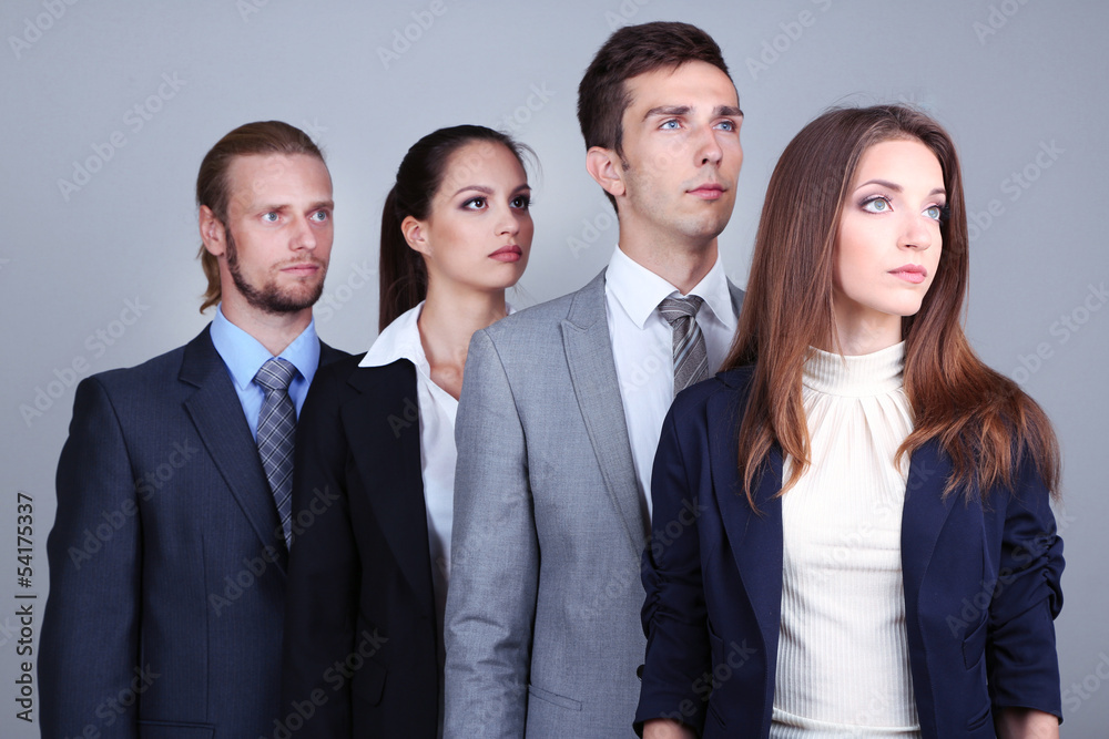 Business team standing in row on grey background Business team standing in row on grey background