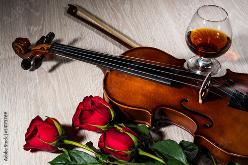 Violin, rose, glass of champagne and music books