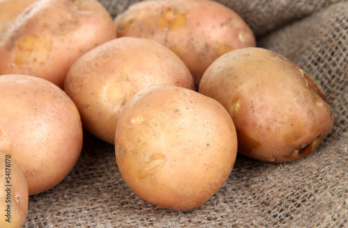 Potato on sackcloth  on wooden table