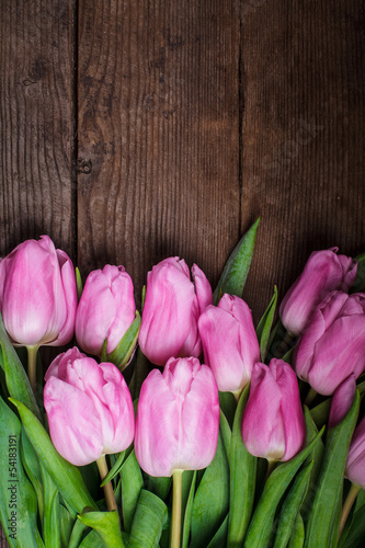 Pink tulips over wooden table