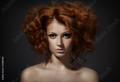 Beautiful woman with curly hairstyle against dark background