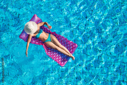 Junge Frau auf der Luftmatratze im Pool