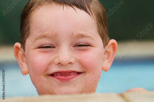 Portrait of smiling  happy child at side of pool