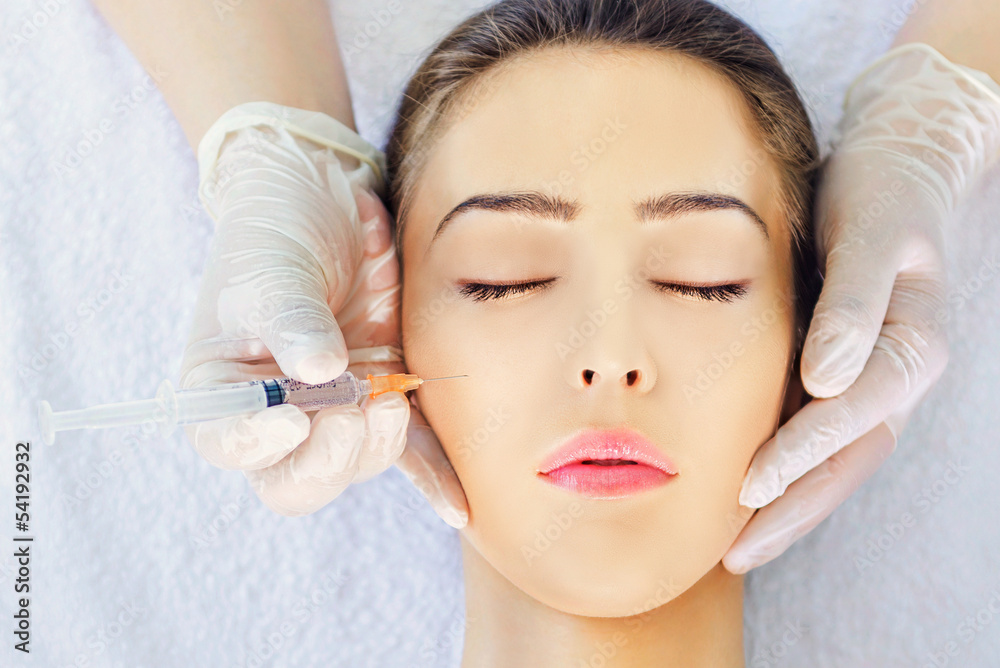 Top view close-up cosmetic injection to woman's cheeks Top view close-up cosmetic injection to woman's cheeks