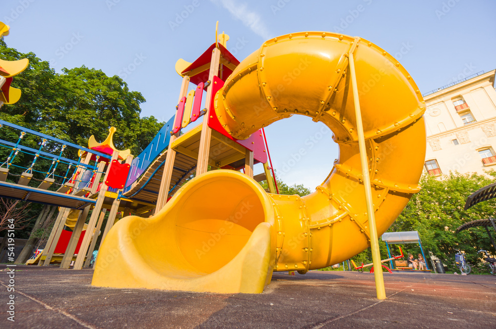 Yellow spiral baby slide on kids playground. Shot from floor lev