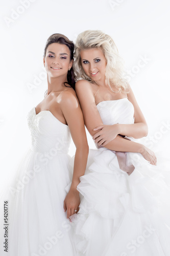 Smiling young girls posing in wedding dresses