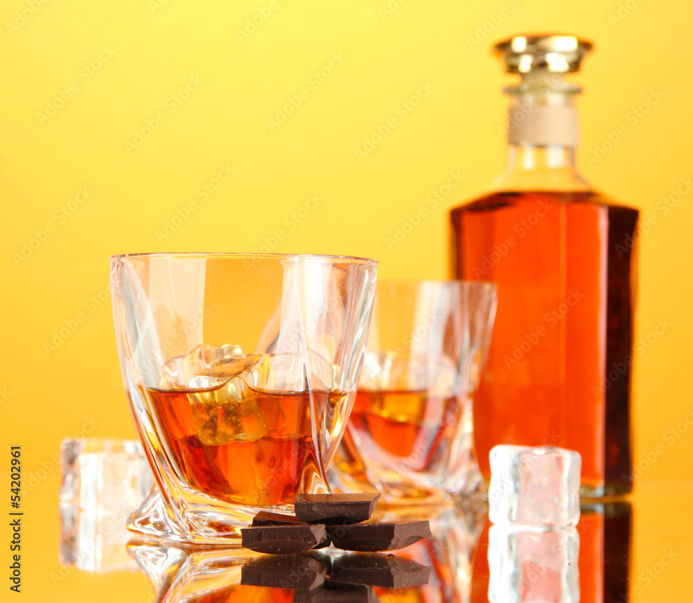 Bottle and two glasses of scotch whiskey, on color background Bottle and two glasses of scotch whiskey, on color background
