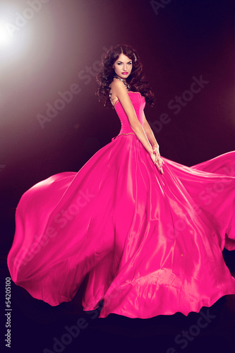 Beautiful woman in gorgeous dress isolated on black background.