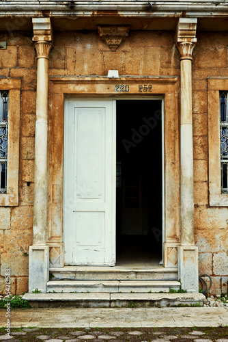 Grungy old door of an old stone house with columns © FreshPaint