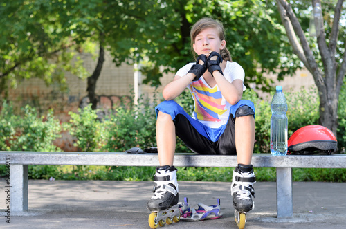 Cute teenager sitting and relaxing during skating