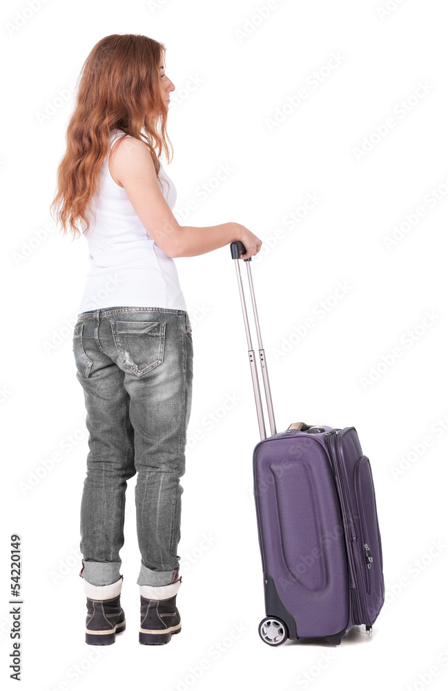 Back view of stylishly dressed woman with suitcase looking up Back view of stylishly dressed woman with suitcase looking up