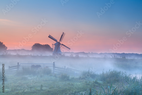Dutch windmill in dense morning fog