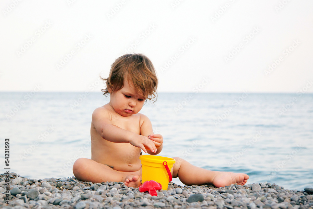 Baby on the beach playing with pebbles. Baby on the beach playing with pebbles.