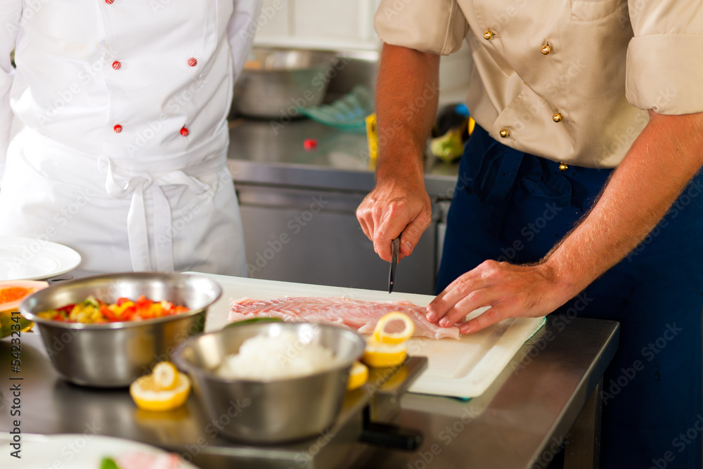 Chefs preparing fish in restaurant or hotel kitchen Chefs preparing fish in restaurant or hotel kitchen