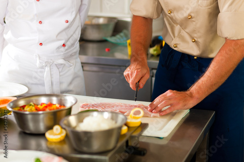 Canvas Print Chefs preparing fish in restaurant or hotel kitchen